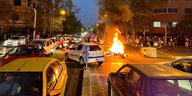 Ein Polizeimotorrad brennt während Protesten im Iran