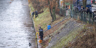 Polizisten stehen am Kanal, im Wasser sind Taucher