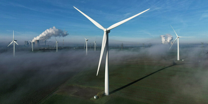 Ein Windrad steht in einem Windräderpark