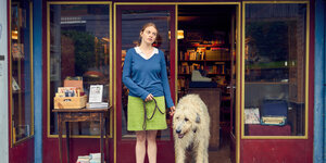 Ein Mädchen mit Hund stehen vor einer Dorfbuchhandlung