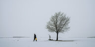Mann mit Wasserkanister und Baum im Schnee