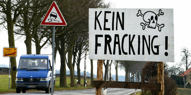 Auf einem Protestschild an einer Straße steht: "Kein Fracking!" neben einem gemalten Totenkopf