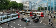 Eine Stadtkreuzung auf der Trams, Autos und Radfahrer durcheinander fahren