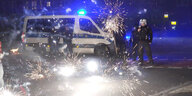 Polizeibeamte stehen hinter explodierendem Feuerwerk in Berlin