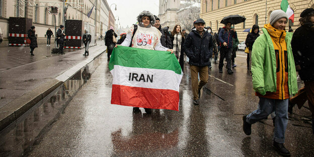 Ein Protestzug mit iranischer Fahne