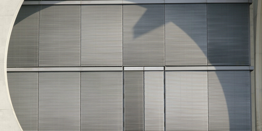 Geschlossene graue Rolläden an glatter Fassade