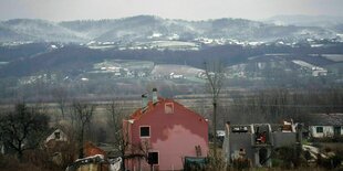 Schneebedeckte Hügel und davor ein Dorf