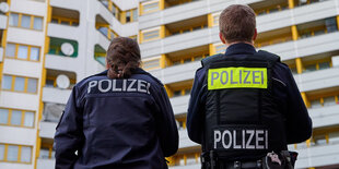 Zwei Polizisten von hinten zu sehen, sie stehen vor dem Zentrum Kreuzberg am Kotti bei einem Protest gegen die geplante Kotti-Polizeiwache