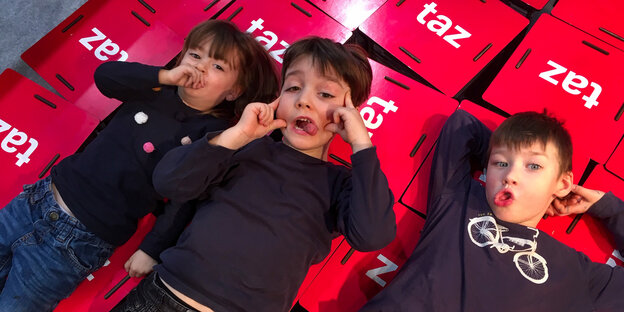 Das Bild zeigt drei Kinder im taz Studio auf der Buchmesse.