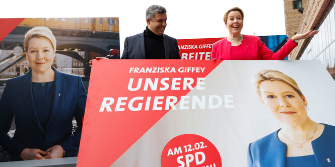 Franziska Giffey steht neben Plakaten mit ihrem Bild