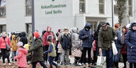 Geflüchtete warten vor dem Ankunftszentrum in Berlin-Reinickendorf.