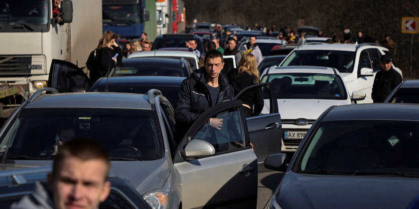 Menschen stehen mit ihren Autos in einem Stau