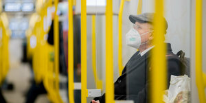 Ein Mann sitzt mit FFP2-Maske in der U-Bahn