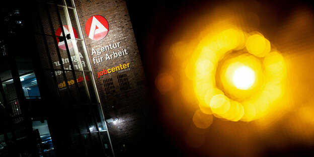 Ein gelbes Licht vor dem Gebäude eines Jobcenters