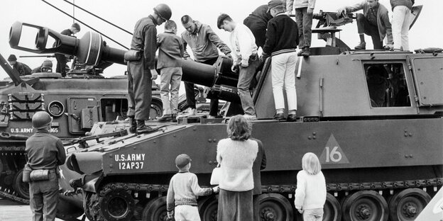 Kinder spielen auf einem Panzer