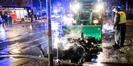 Ein Polizeifahrzeug räumt brennende Gegenstände von der Fahrbahn