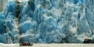 Ein Boot fährt an einem Gletscher vorbei