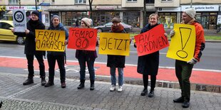 Menschen mit bunten Plakaten stehen in einer Reihe