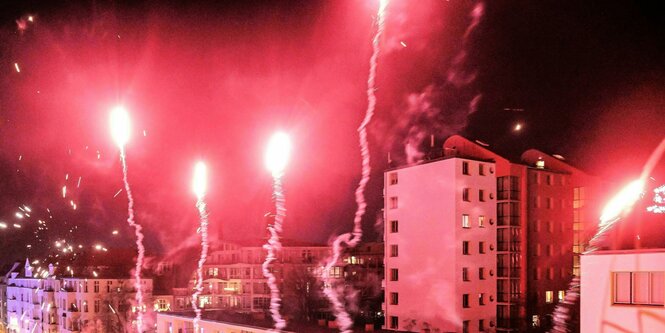 Silvesterraketen vor Nachthimmel in Hochhaussiedlung