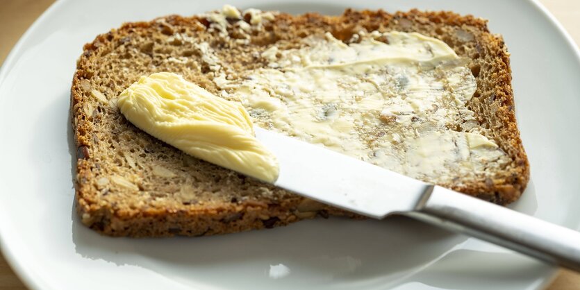 Ein Messer mit Streichfett auf einer Brotscheibe