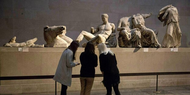 Drei Frauen stehen vor Marmorskulpturen in einem Museum