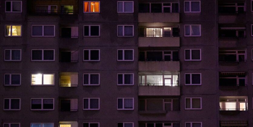 Mehrfamilienhaus in dem einzelne Lichter brennen