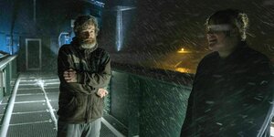 Peter Faber steht mit einer Frau im Schneesturm auf einer Brücke und friert