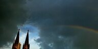 Kölner Dom mit dunklem Himmel und Regenbogen