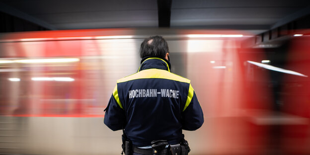 Ein Mitarbeiter der Hochbahn-Wache steht an einem Bahnsteig.