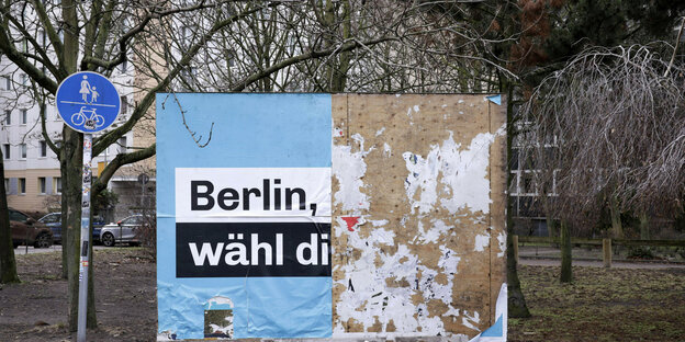 Eine große Plakatwand ist mit einem halben Wahlplakat bedeckt. Es handelt sich um das Wahlplakat der CDU Berlin wähl dich neu.