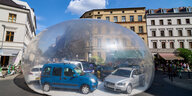 Kunstinstallation mit Autos in einer Plastikblase.