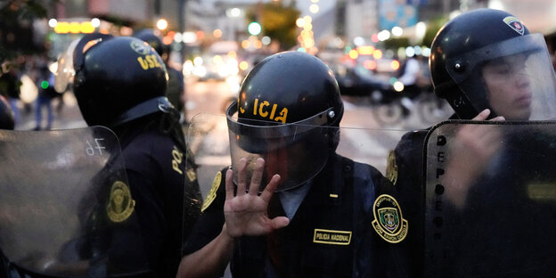 Policemen behind shields on a street