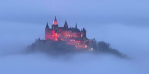 Die Burg Hohenzollern ragt aus dem Nebel hervor.