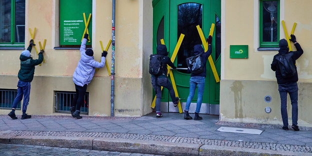 Yellow X battens are nailed to the entrance and windows of the Greens' Federal Office