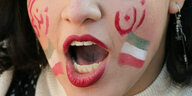 Das mit den Farben des Irans bemalte Gesicht einer Person