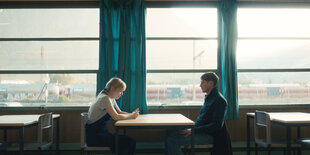 Der Polizist Yohan (Bastian Bouillon) und Nanie (Pauline Serieys) sitzen in einem sterilen Café.