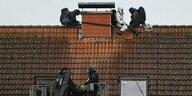 Hausbesetzer und Polizei auf dem Dach