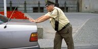 Ein Polizist schiebt ein Auto