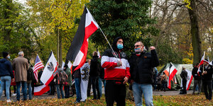 Menschen mit schwarz-weiß-roten Fahnen stehen auf einer Demonstration