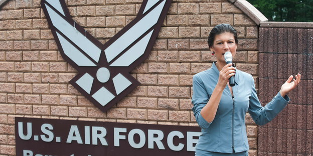 Sahra Wagenknecht steht vor einem Emblem der U.S. Air Force in Ramstein