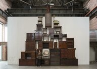 Henrike Naumann vor ihrer Installation, aufgestapelte Möbel im US-amerikanischen Repräsentantenstil