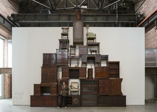 Henrike Naumann in front of her installation, stacked furniture in the American representative style