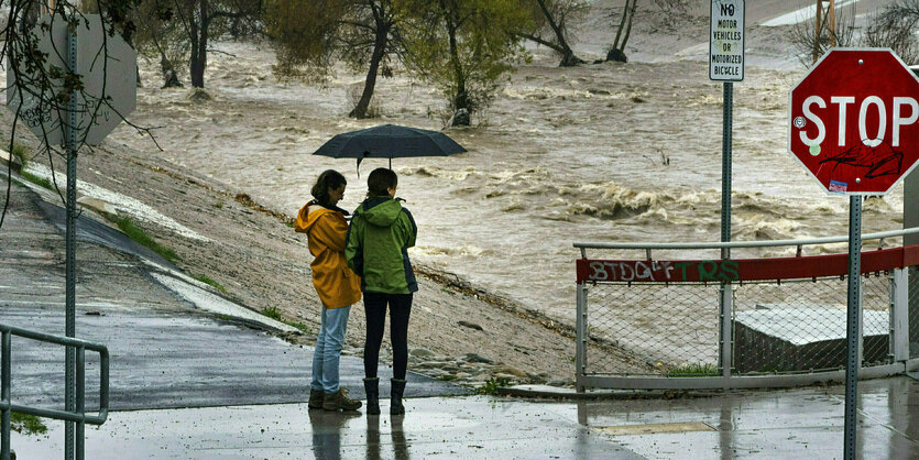 Zwei Menschen stehen unter einem Regenschirm