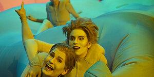 Leandra Enders und Lisa Eder in gelben Ganzkörperanzügen in "Der staubige Regenbogen"
