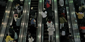 Reisende in Peking auf der Rolltreppe