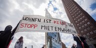 Aktivist*innen halten ein Banner vor den Hochhäusern am Potsdamer Platz. Darauf steht: "Wohnraum ist keine Ware - stopp den Mietenwahnsinn"