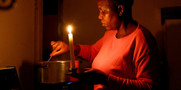 One person cooks by candlelight