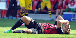 Ein Fußballspieler liegt auf dem Rasen