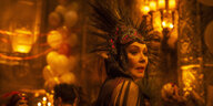 Elinor St. John (Jean Smart) steht in extravaganter Abendgaderobe in einem schummrig beleuchteten Ballsaal.