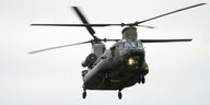 Ein olivgrüner Hubschrauber vom Typ Chinook mit zwei Rotoren im Anflug
